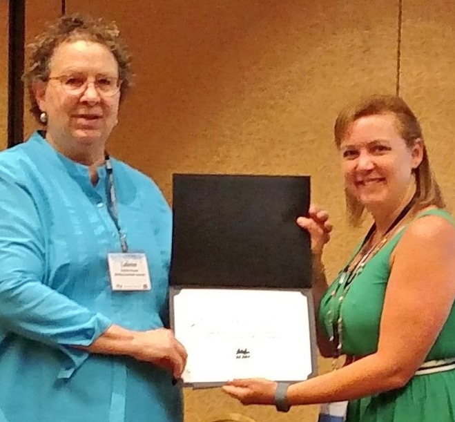 Dr. Catherine Cassara of Bowling Green State University presented the Association of Journalism and Mass Communication Editors' third-place Best Practices in Teaching Award to Dr. Jennifer Brannock Cox.