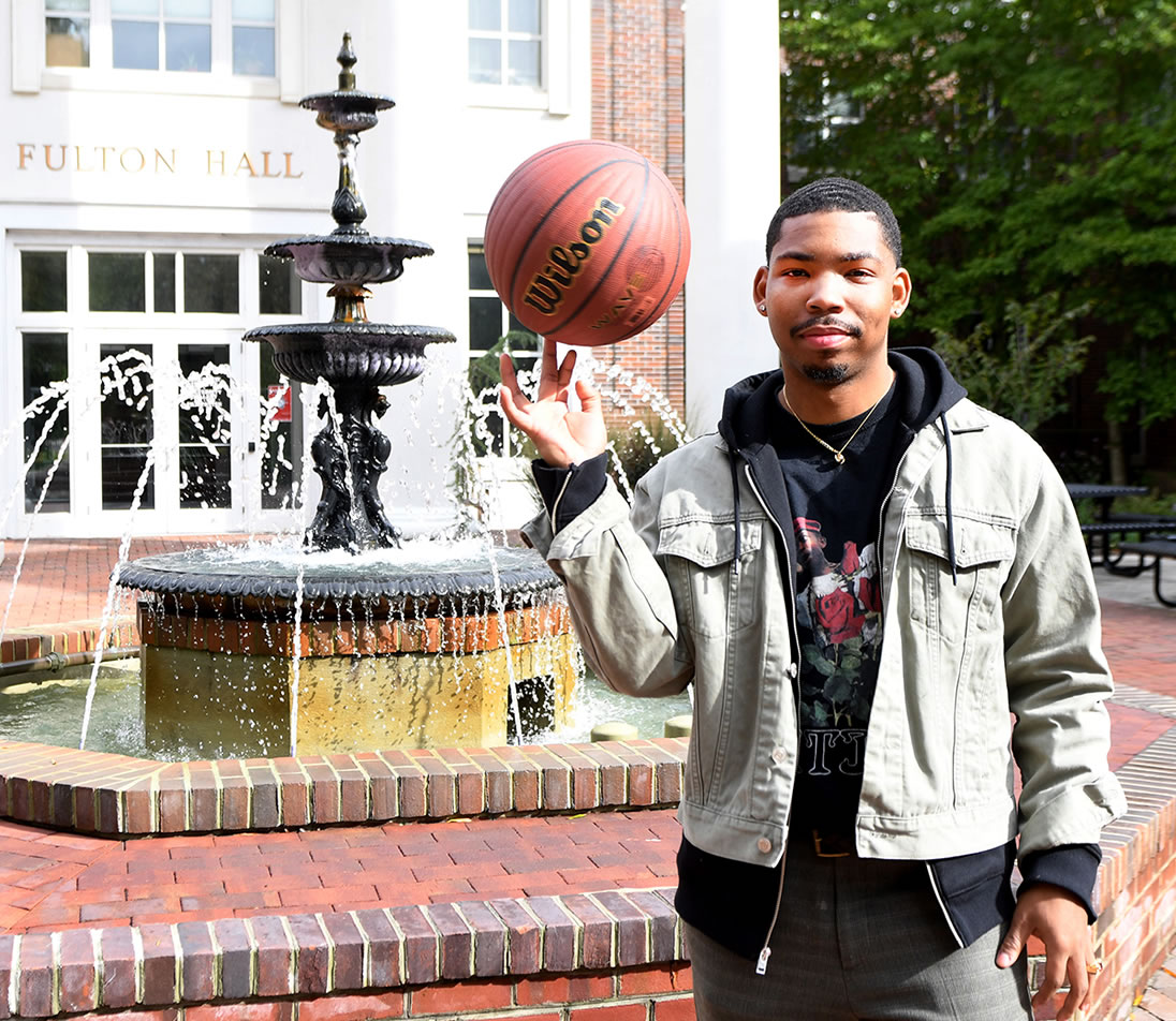 Student in front of Fulton Hall