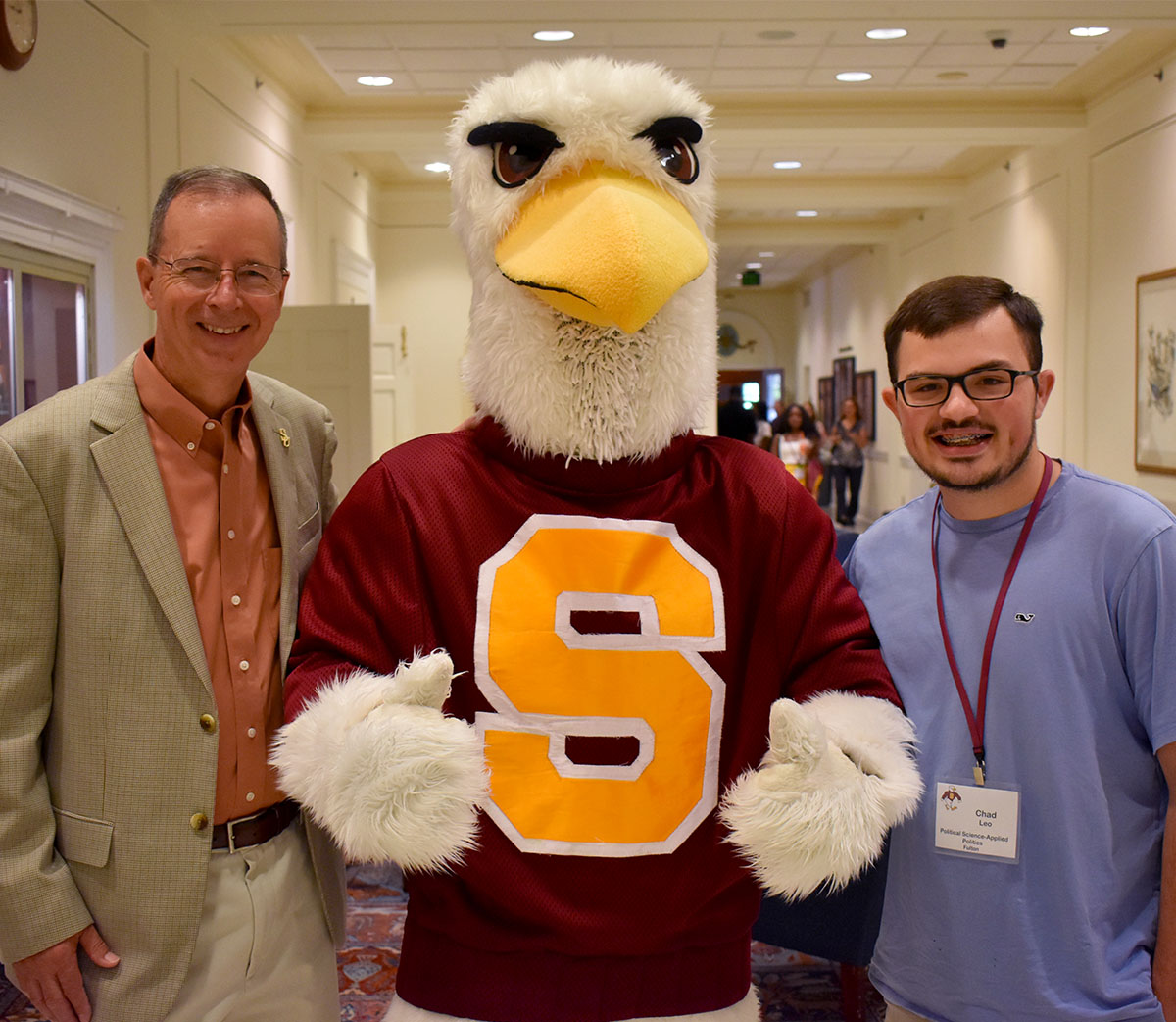 SU President Charles Wight with Sammy the Sea Gull and SU Student Chad Leo