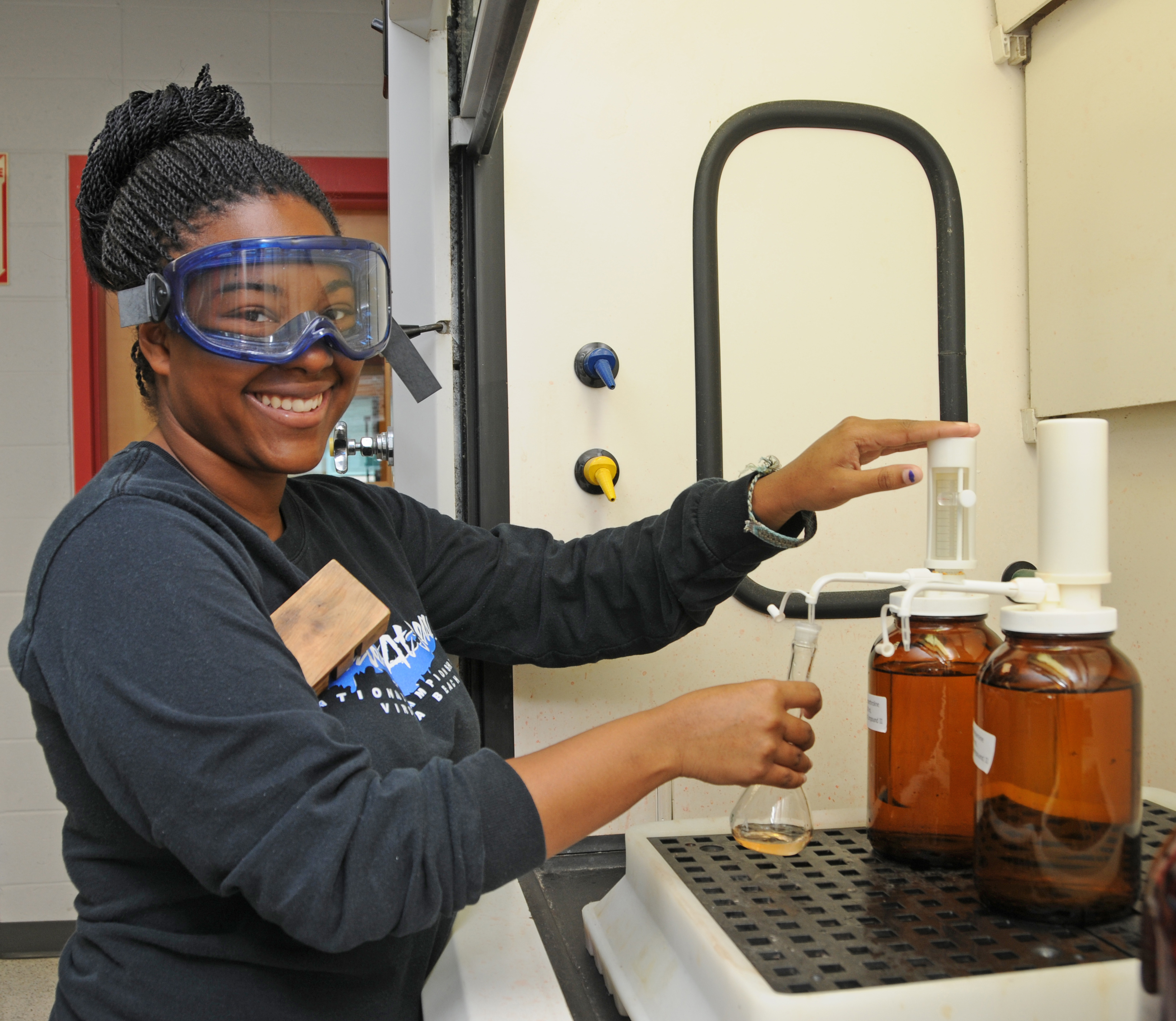 Science student holding beaker in lab.