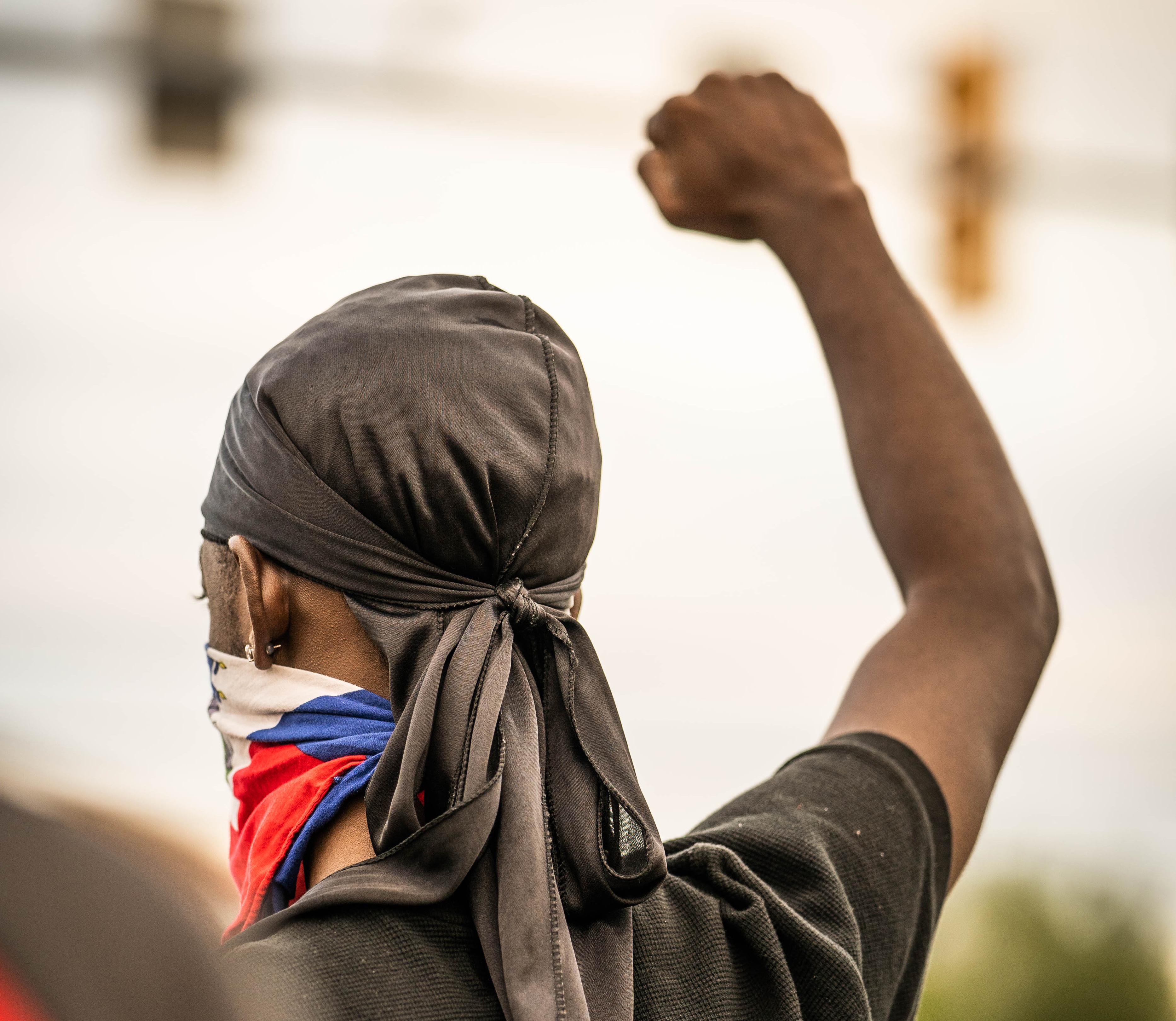 man with back to camera fist raised