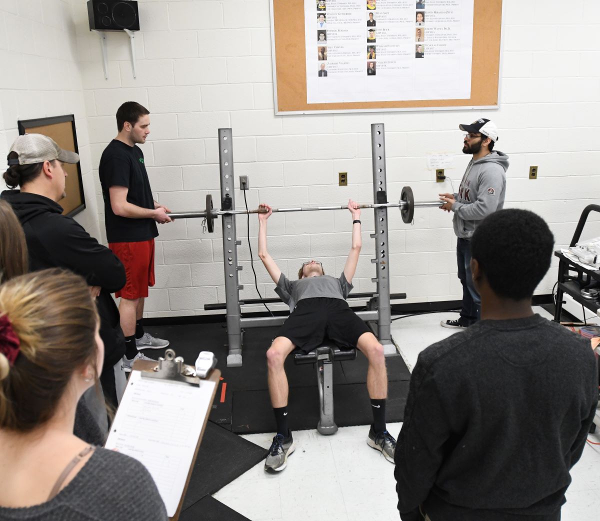 Exercise science students in gym lifting weights
